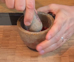 Crush peppercorns in a mortar